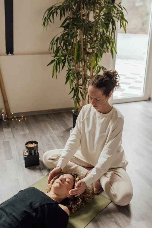 Une naturopathe et sa cliente effectuant une séance de Reïki.